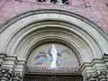 Tympan du portail de l'église où est représentée l'Immaculée Conception. La fresque a été réalisée sur le tympan en 1954 pour fêter le centenaire du dogme de l'Immaculée Conception proclamé par l'église catholique le 8 décembre 1854 par le pape Pie IX.