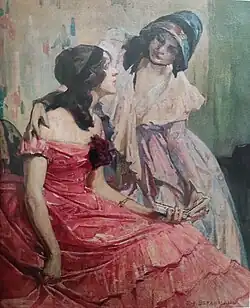 Deux femmes, la première est habillée en rouge avec un ruban noir dans les cheveux, elle est assise un livre à la main. Elle lève la tête pour s'adresser à la deuxième qui est debout à côté d'elle et l'écoute, légèrement penchée avec une main posée sur son épaule.
