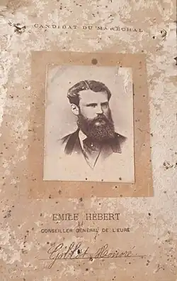 Affichette imprimée reproduisant la photographie en buste d'un homme barbu.