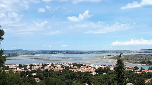 Étang de Lapalme depuis les hauteurs de la Franqui. Au loin, sous les éoliennes : la ville de La Palme.