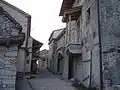 Sur la gauche, un angle de la Maison du Karst avec son toit de lauzes et sa gouttière en pierre