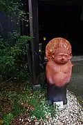 Une statue de tanuki reprenant des éléments d’un bouddha.