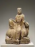 • Bodhisattva Avalokiteśvara rugissement du Lion, ou  Siṃhanāda Avalokiteśvara (identifié à Shi Hou Guanyin).• Époque: Dynastie Ming fin XVe début XVIIe&nbsp;siècle.• Bois de peublier monobloc avec pigments.• Hauteur: 107 cm.• Metropolitan Museum of Art, New-York.
