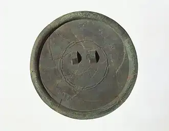 Miroir de bronze au décor linéaire en très fin relief, dont motifs «&nbsp;en étoile rayonnante&nbsp;» et frise de bandes en «&nbsp;positif-négatif&nbsp;». Site de Daegok-ri