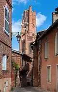 Rue des prêtres, ruelle médiévale en brique rouge.