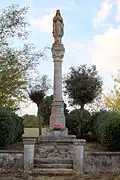 Une statue de la Vierge posée en haut d'une colonne sculptée