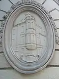 Médaillon à l'angle sud, montrant l'ancienne façade du bâtiment.