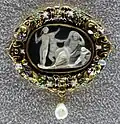 Bijoux oval sculpté blanc sur fond noir avec 2 personnages.