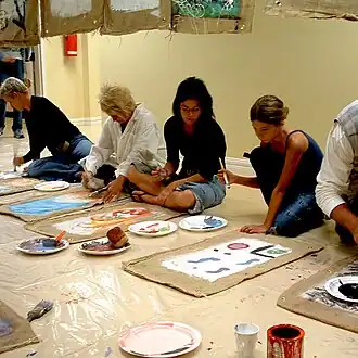 60 poches de jute sont peintes par une vingtaine de participants à la Maison des Bâtisseurs.