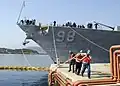 Des lamaneurs grecs tirent les amarres du Forrest Sherman (DDG 98), navire de la classe Arleigh Burke, arrivant en Grèce pour sa première visite au port lors de son premier déploiement.