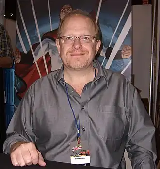 photo en couleur rapproché taille de Mark Waid assis derrière une table
