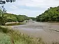 Le moulin à marée du Hénan vu du fond de l'étang du Hénan à marée basse.
