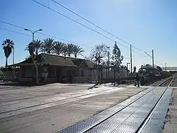 Ciel bleu. On voit au loin l'entrée au quai, et, au premier-plan, les rails.