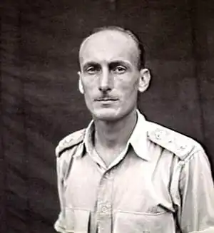 Portrait en buste d'un homme en chemise militaire.