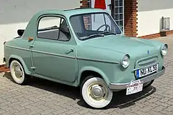 Une voiture turquoise vue de l'avant droit.