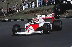 Photo d'une voiture de Formule 1 rouge et blanche sur une piste de circuit