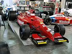 Photo d'une monoplace rouge surélevée, dans un musée