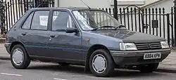Photo d'une Peugeot 205 grise foncée dans une rue au Royaume-Uni.
