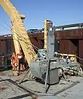 Le carottier est muni d'une boîte cubique, pour la collecte d'échantillons du fond marin.