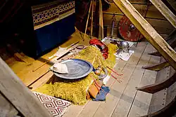 Photographie d'une chambre funéraire reconstituée, avec divers objets entourant le défunt.