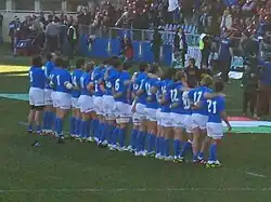 Photographie d'une équipe de rugby en ligne, portant des maillots bleus