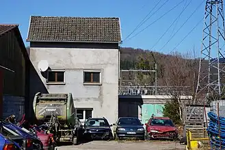 Panneau en bois devant un grillage.