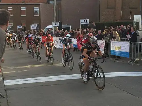 106.7&nbsp;km: Groupe de onze coureuses sur la ligne d'arrivée partant pour le dernier tour