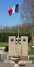 Stèle cubique et drapeau français.