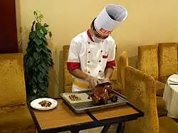 Découpage du canard devant les clients d'un restaurant gastronomique de Pékin.