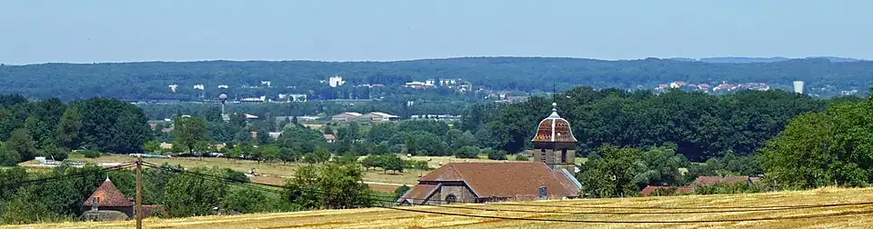 Vue éloignée de l'église et du château de Brotte-lès-Luxeuil avec la BA 116 et la ville de Luxeuil-les-Bains en arrière-plan.