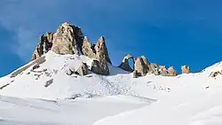 Vue hivernale de l'arche naturelle dominée par le sommet.