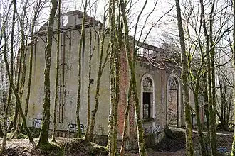 Une façade à quatre grandes ouvertures, la plus grande est desservie par un petit escalier.