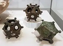 Deux dodécaèdres et un icosaèdre. Rheinisches Landesmuseum Bonn. Les dodécaèdres proviennent de Bonn et Frechen-Bachem, l'icosaèdre d'Arloff.