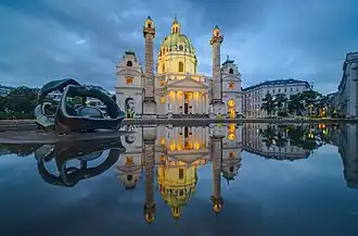 Une église monumentale avec une sculpture métaphysique entre chien et loup.