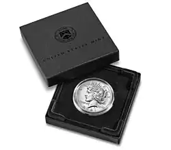 Boîte de couleur sombre contenant une pièce de monnaie. Le couvercle comprend l'inscription United States Mint et un écusson.