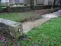 Saint-Thuriau : le ruisseau de la Fontaine Névé en période de fortes pluies à proximité de la chapelle de Gohazé et juste avant sa confluence avec le Blavet. Le cercle sur le muret indique le niveau atteint par l'eau lors de la crue du Blavet en janvier 2001.