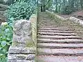 Locuon ː l'escalier et la statue mutilée de la déesse-mère replacée en bas de l'escalier.
