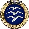 Insigne: Disque bleu entouré d'une couronne d'or avec 3 mouettes empilées en vol Insigne d'or surmonté de 3 diamants