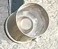 Vue de l'intérieur d'une douille déjà utilisée d'un grenade de 40&nbsp;mm. On distingue la chambre à haute pression interne, qui diminue la pression produite lors de la mise à feu de la cartouche.