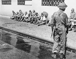 Un soldat de la 5e division indienne surveille des prisonniers de guerre japonais.