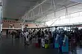 Hall des départs, comptoirs d'enregistrement et accès aux zones d'embarquement.