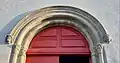 Modillons du XIVe siècle visibles au dessus de la porte d'entrée de l'église.