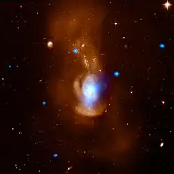 Image composite provenant des données rayon X (bleu) du télescope spatial Chandra et des données en lumière visible (orange) captées par le télescope spatial Hubble.