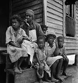 « Un dollar par jour. Famille d'un travailleur de la térébenthine près de Cordele, en Alabama. Le salaire du père est d'un dollar par jour. C'est le niveau de vie que ces gens là supportent ». Juillet 1936.