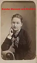 Femme appuyée sur un accoudoir.