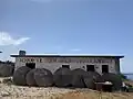 Bâtiment abandonné à Porto Palermo, contenant un ancien message socialiste "Vive l'amitié albano-chinoise" (RROFTE MIQESIA SHQIPTARO-KINEZE).