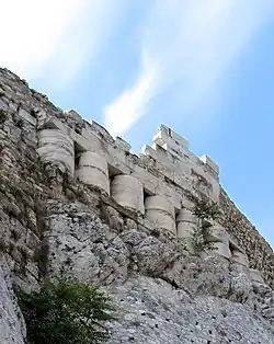 Photographie couleur d'un côté de l'Acropole avec l'utilisation visible de pierre d'un autre bâtiment.