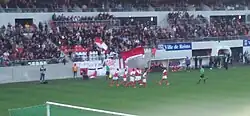 Des joueurs se félicitent en bas d'une tribune