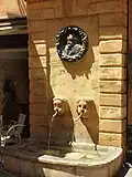 Fontaine des Bagniers, &nbsp;Inscrit MH (1949), le bronze est un portrait en médaillon de Paul Cézanne par Auguste Renoir (don d'Ambroise Vollard à la ville en 1926)