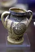Graphie d'une pièce en céramique verte et manganèse, au musée archéologique de la citadelle de Malaga